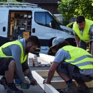 Apprentices working, with van in background