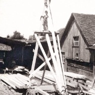 Photos of a very high timber framework with a worker and child at the top.