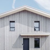 Exterior view of the detached house: an abundance of wood in different structures and colours.