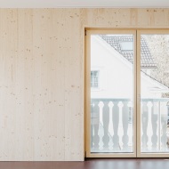 Living room with timber wall and balcony doors