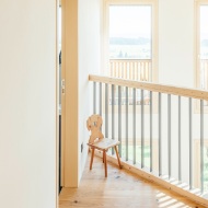 Top-floor mezzanine with railing and wood flooring. 