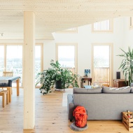 Espace salon et salle à manger ouvert de la maison individuelle avec colonne en bois et plafond Lignatur.