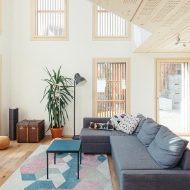 Salon de grande hauteur avec de nombreuses fenêtres et un plafond et un plancher en bois