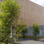 The photograph shows the green spaces and gravel area decorated with a water basin to the rear of the Hotel Säntispark. A covered lounge can also be seen.