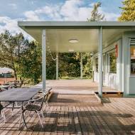 Hellgrüner Sportfeldpavillon mit Terrasse und Sitzmöbeln