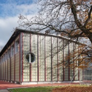 Die temporäre Sporthalle Enge mit vertikaler Holzkonstruktion in Herbststimmung