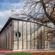 Die temporäre Sporthalle Enge mit vertikaler Holzkonstruktion in Herbststimmung