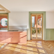 Kitchen in an accenting colour with wooden floor and green interior features