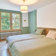 Schlafzimmer mit Holz-Fussboden und hellgrünen Akzenten<br/><br/>