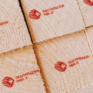 Close-up of square timber, printed with the Swiss timber logo