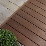 Close-up of a hardwood terrace alongside a green plant and rockery