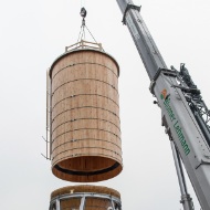 Silo rond en bois dans l’air, suspendu à la grue