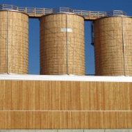 Installation complète intégrée dans le hangar à Eschlikon (CH), composée de trois silos ronds en bois et d’estrades sur le toit, également en bois 