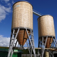 Gesamtanlage in Gesigen bei Spiez bestehnd aus zwei runden Silos aus Holz verbunden mit einem Dachübergang aus Stahl