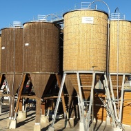 Gesamtanlage in Wolfurt (AT) bestehend aus acht runden Silos aus Holz, Stahlunterbau und Stahlpodeste sowie Stahlleiter