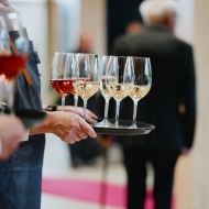 Servicepersonal mit Tabletts voller Weiss- und Rosewein-Glaeser beim Apero zum 150-jaehrigen Jubilaeum von Blumer Lehmann.