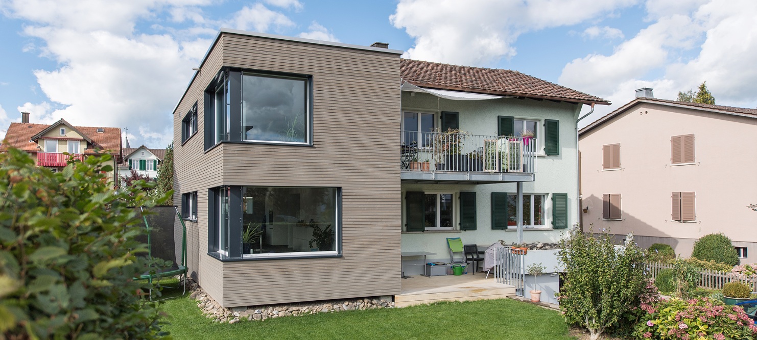 Gesamtansicht des Einfamilienhauses mit modernem Anbau und Garten im Wohnquartier.