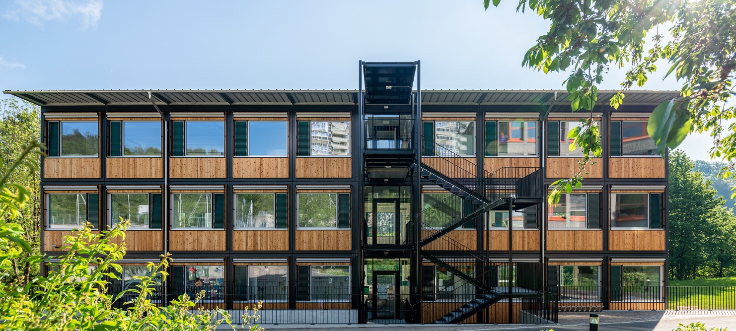 Overall view of the ZM10 Sihlweid school pavilion in Zurich from the front with plants in the foreground
