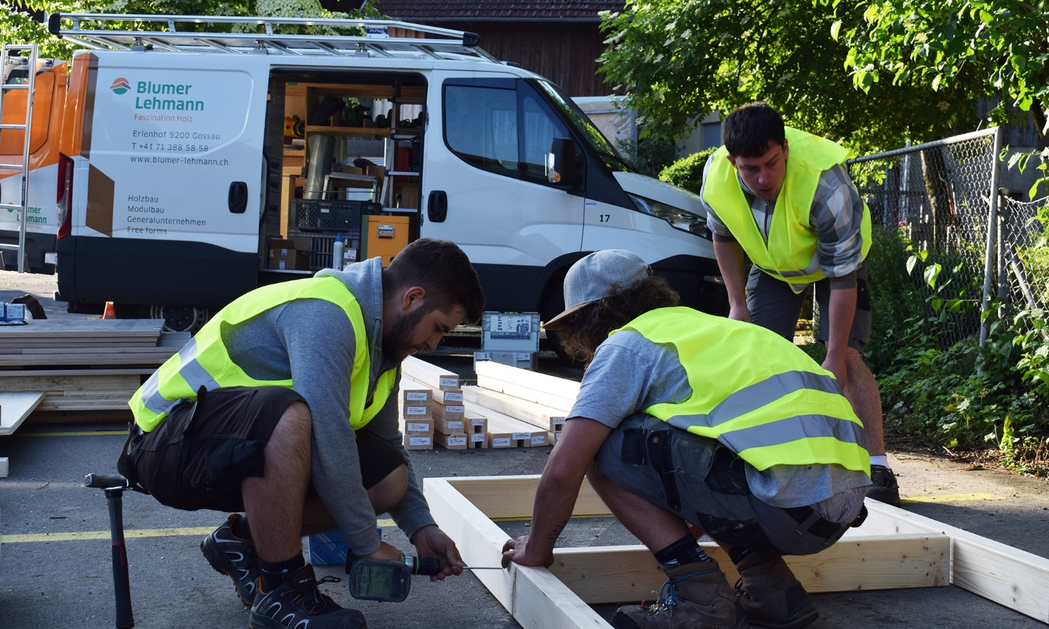 Lernende am Arbeiten mit Lieferwagen im Hintergrund