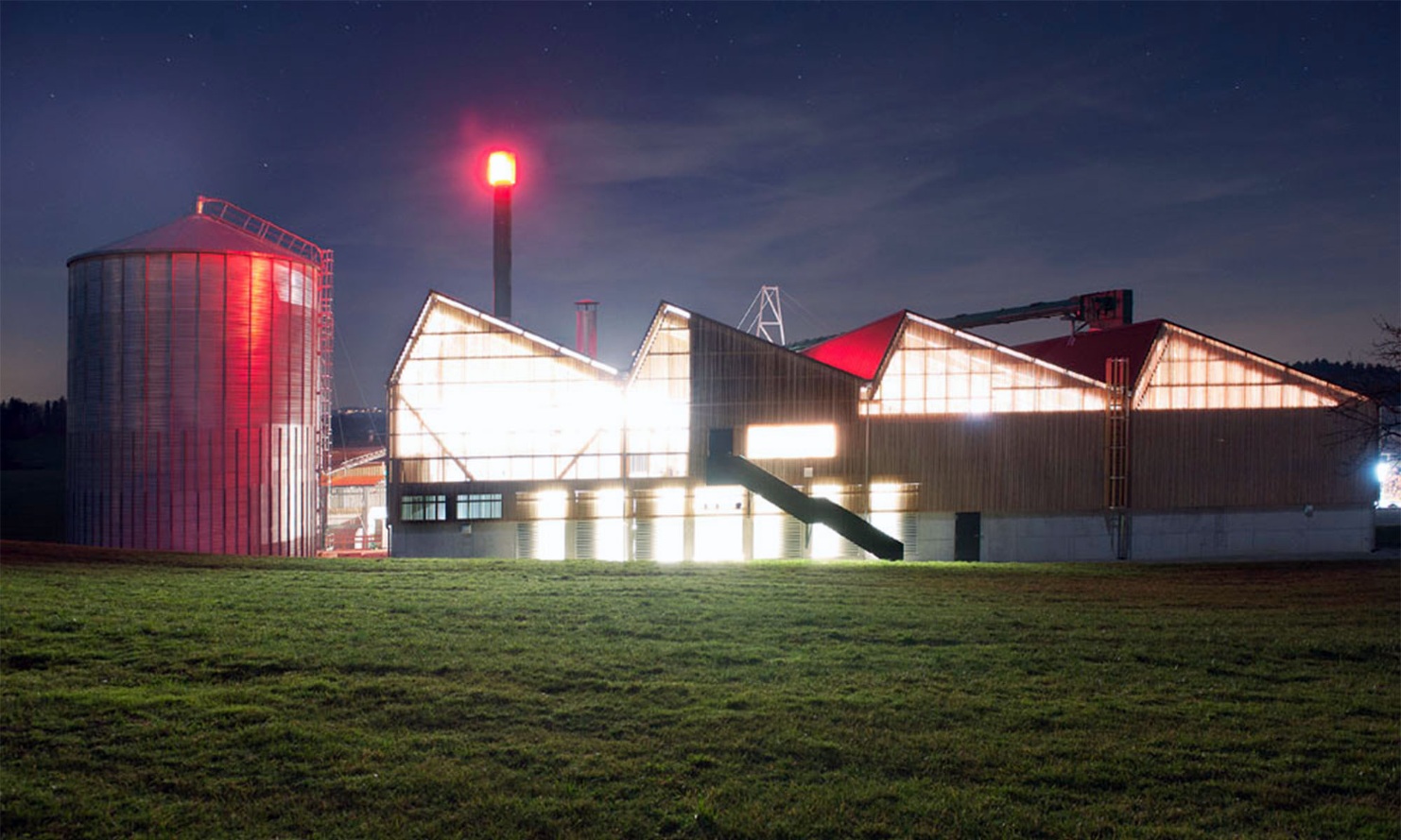 Photo de nuit du bâtiment illuminé de la centrale électrique à l’Erlenhof