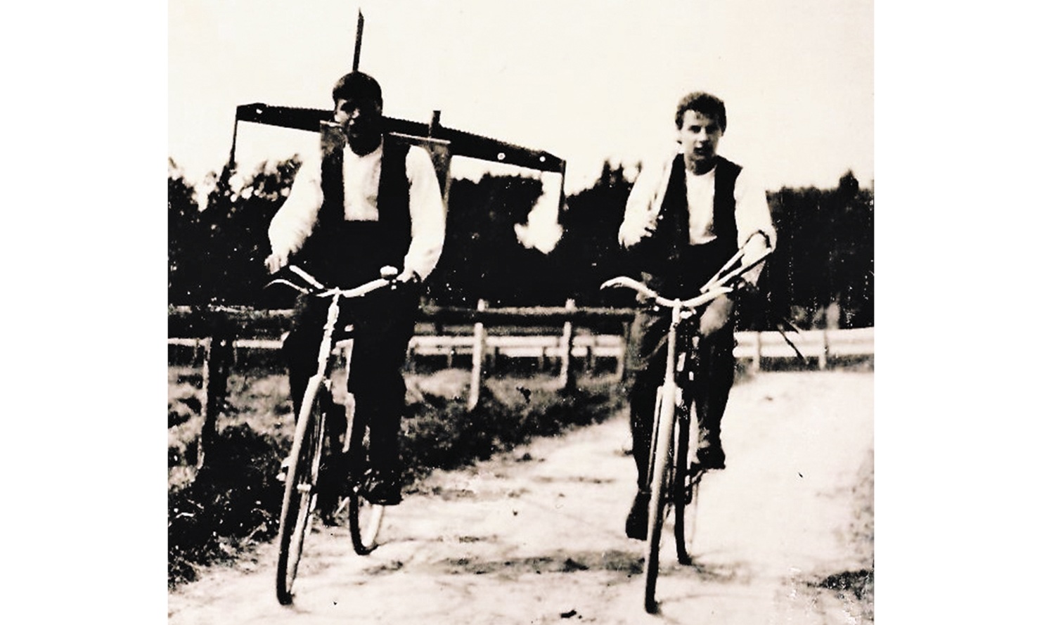 Very old photo of two carpenters on a bicycle