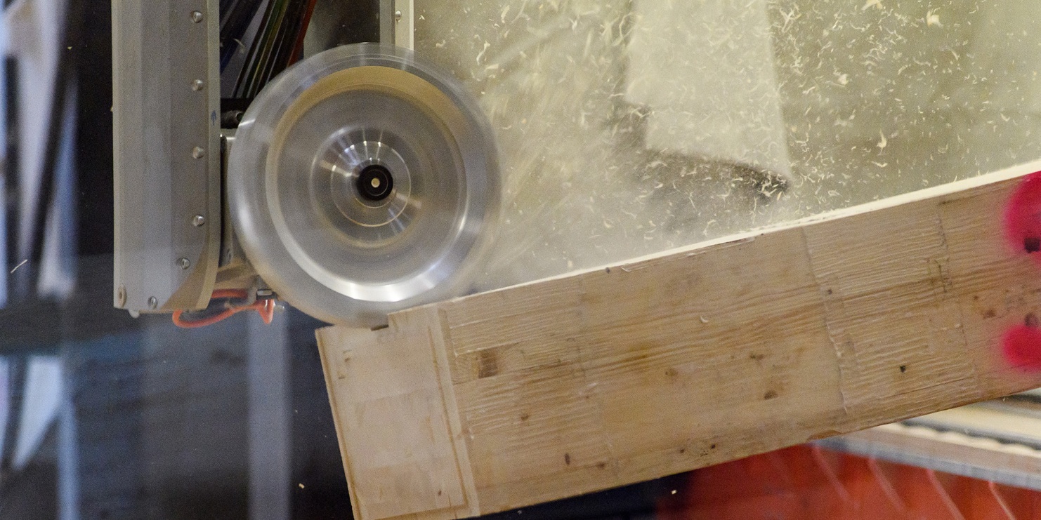 The milling head processes the piece of wood on the CNC machine. The shavings fly off.