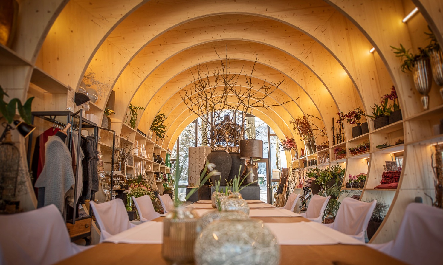 Interior view of the flower shop with a large table in the centre of the picture.