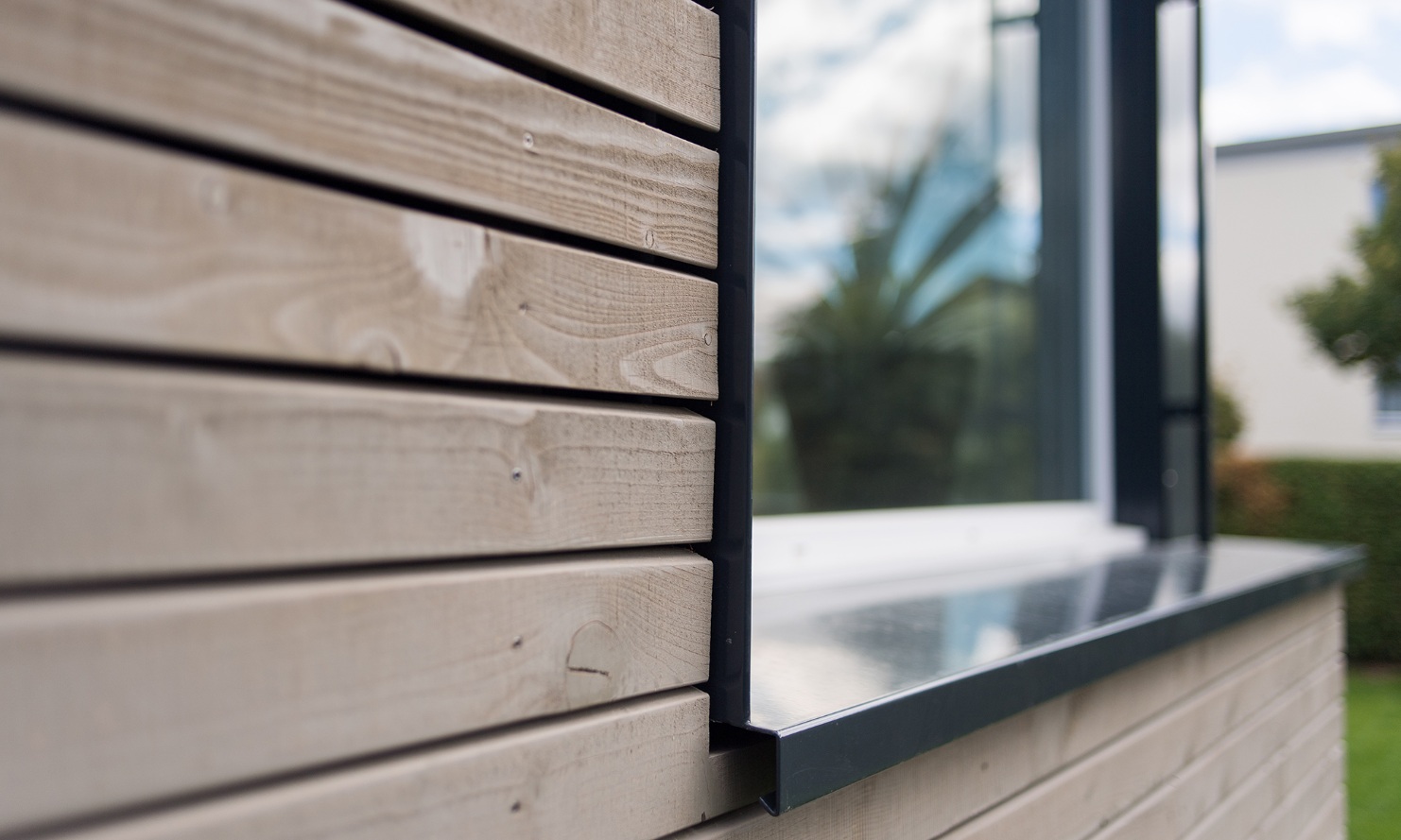 Detailed view of the new extension on the single-family home; timber facade with window.