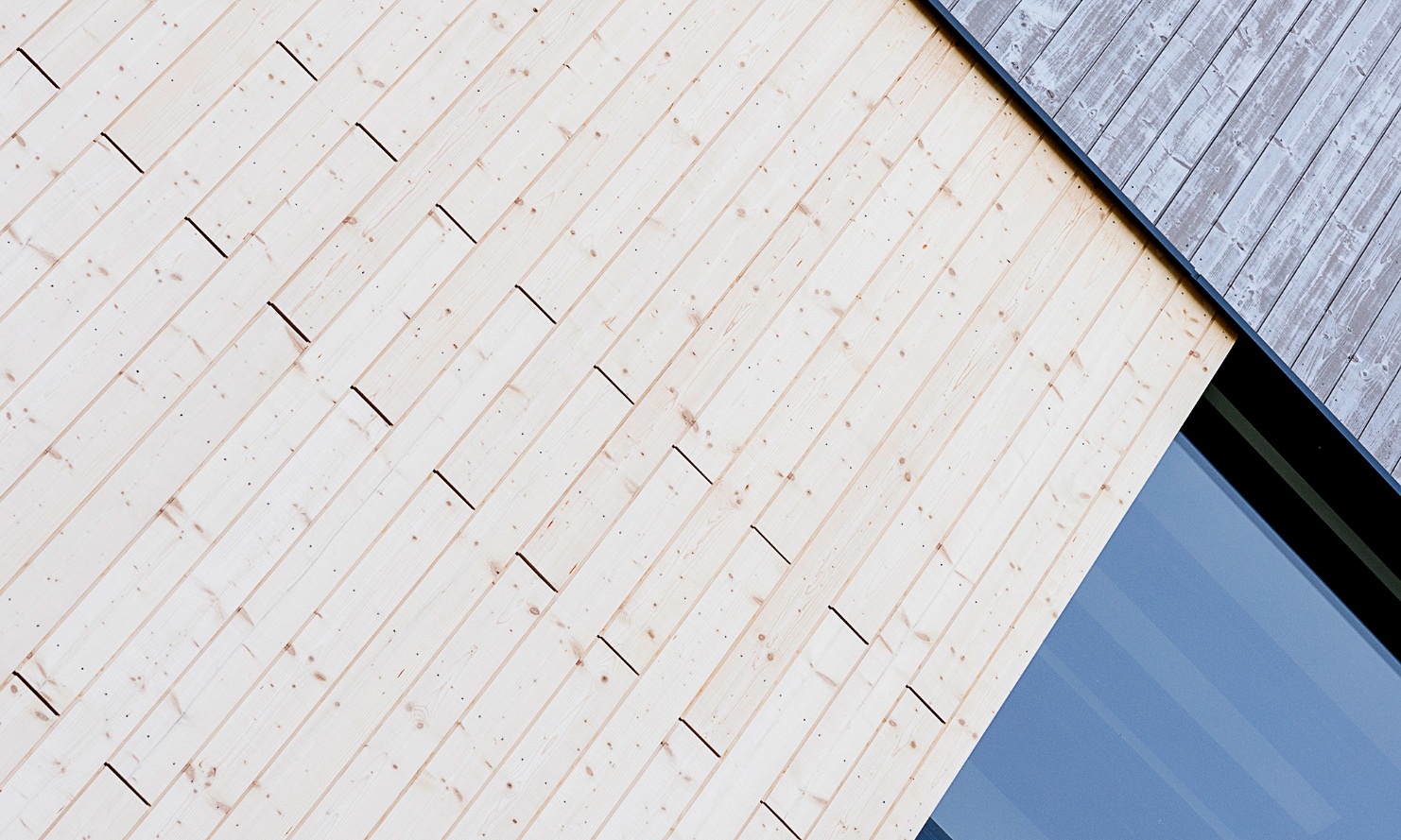 Vue détaillée de la façade de la centrale électrique avec une comparaison directe des différents traitements de façade; bois pré-gris et bois traité UVood.