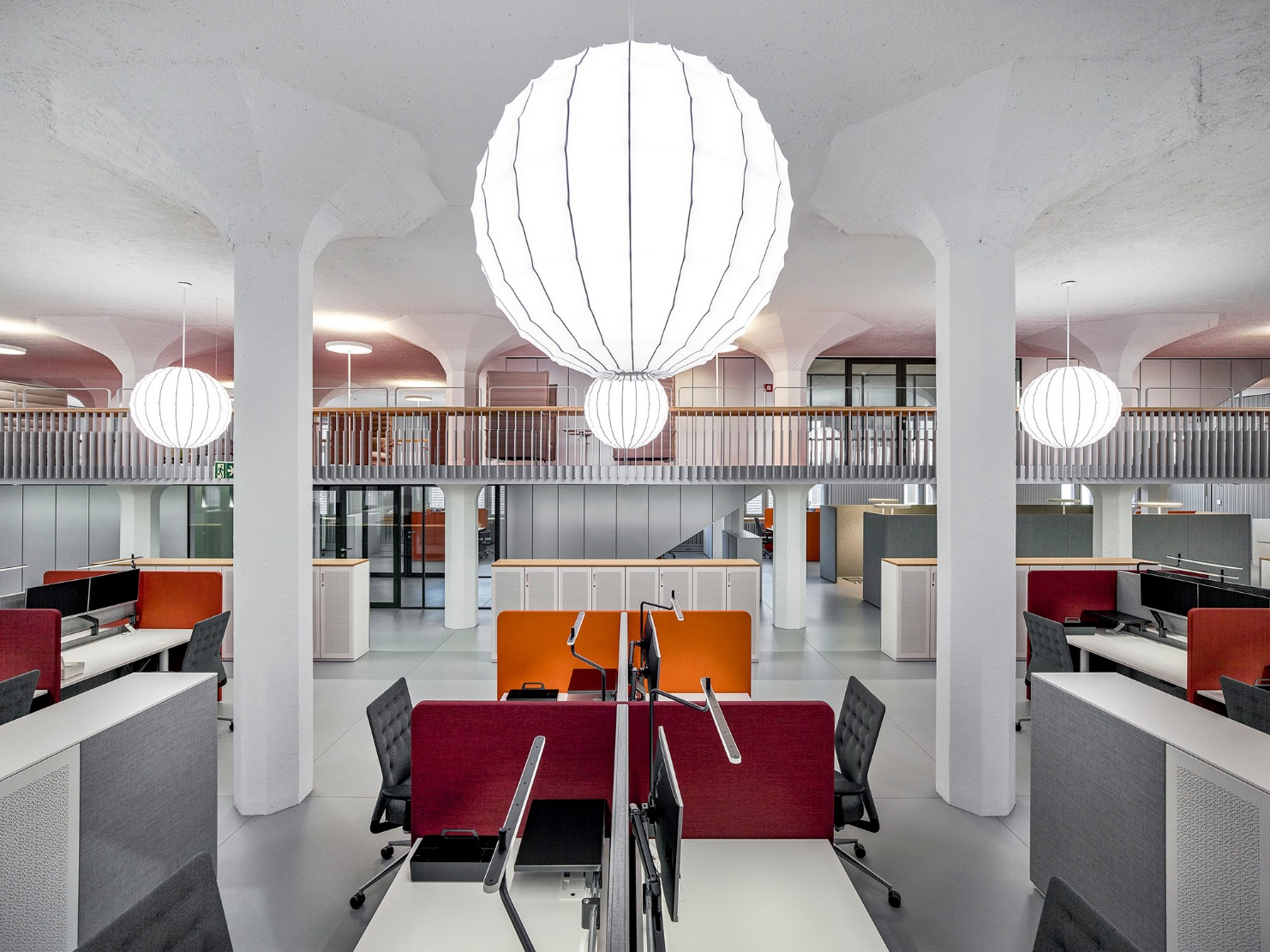 Blick in die modern und hell eingerichteten Büroräumlichkeiten der Firma Givaudan. Es überwiegen die Farben Weiss und Rot. An der Decke hängen asiatische angehauchte Lampen. 