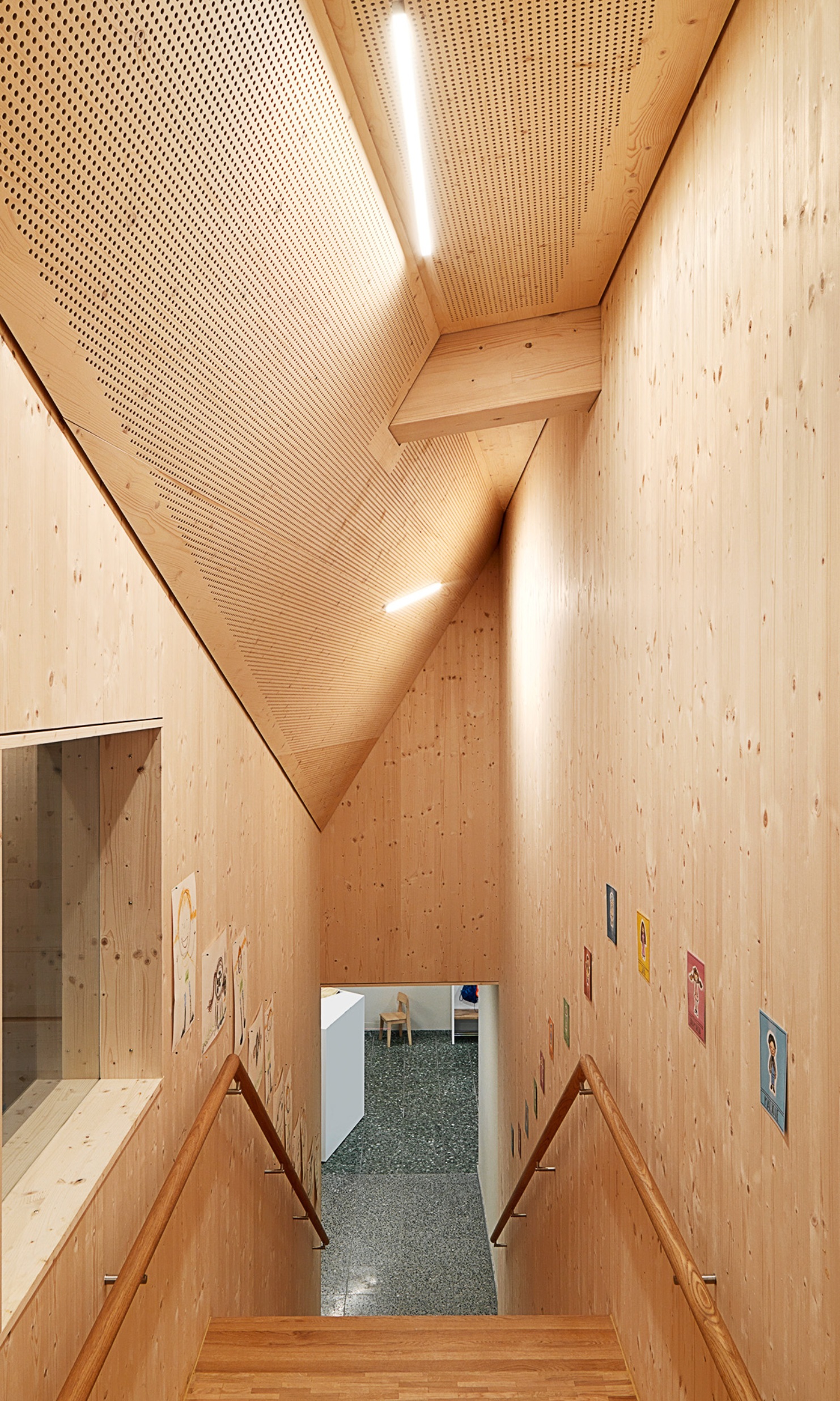 Treppenhaus aus Holz im Kindergarten Wittenbach, der im Obergeschoss einen Vorbau mit zusätzlichen Klassenzimmern erhielt.