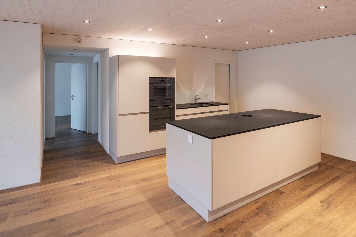 Interior view of one of the 42 flats in the Sunnehof complex. Also here, wood determines the appearance: The ceiling, floor and kitchen combination are made of wood. 