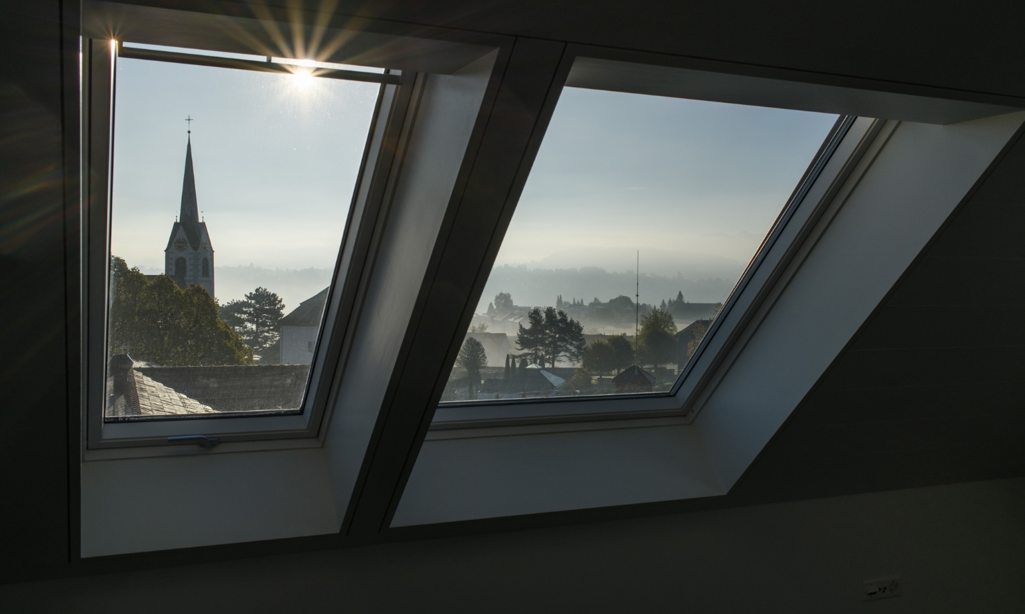 Vue depuis la fenêtre du dernier étage d’un immeuble collectif à Berg sur l’église voisine et vue panoramique sur les toits des maisons