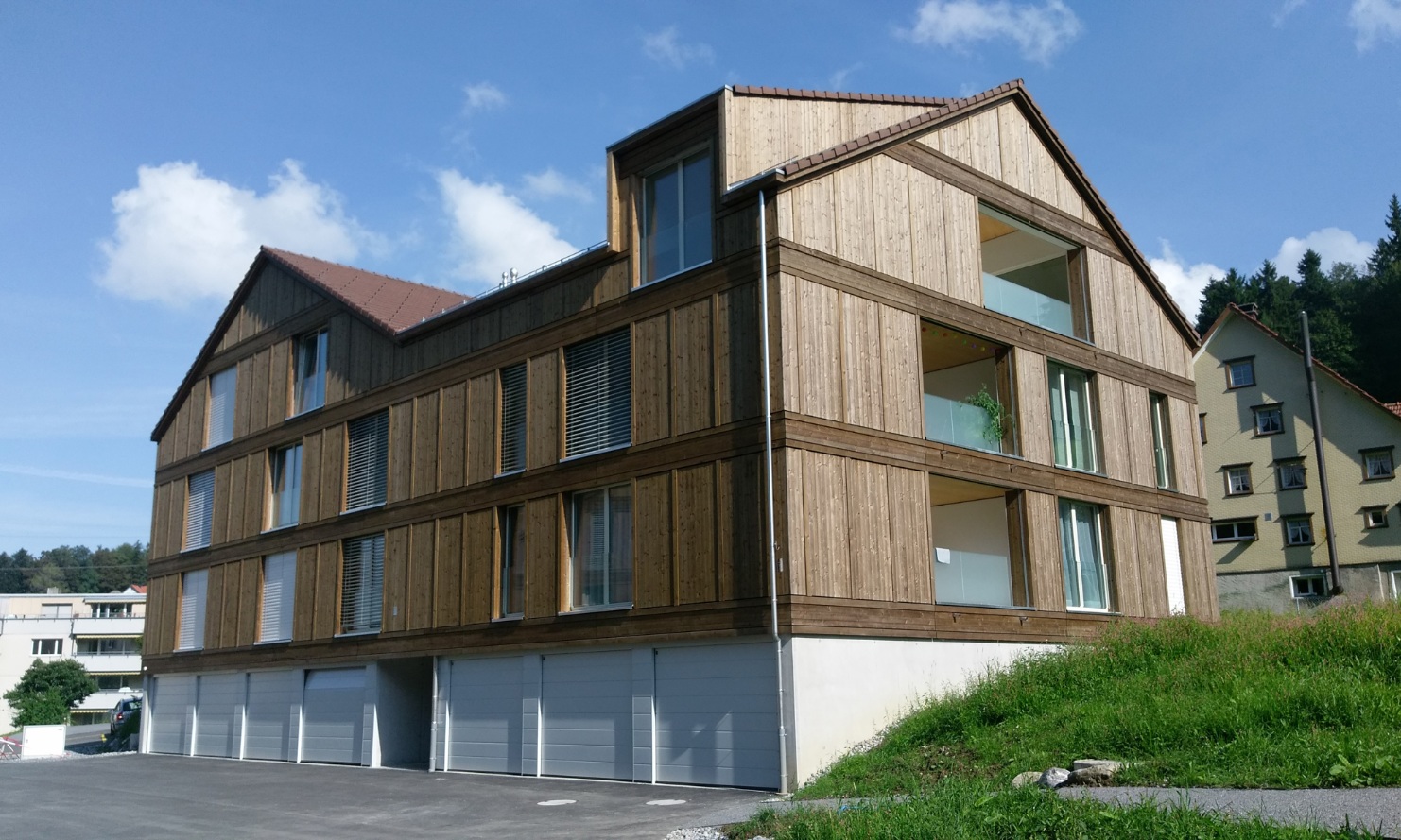 The photograph shows the forecourt and garage spaces of the Mattenbach apartment building in Grub