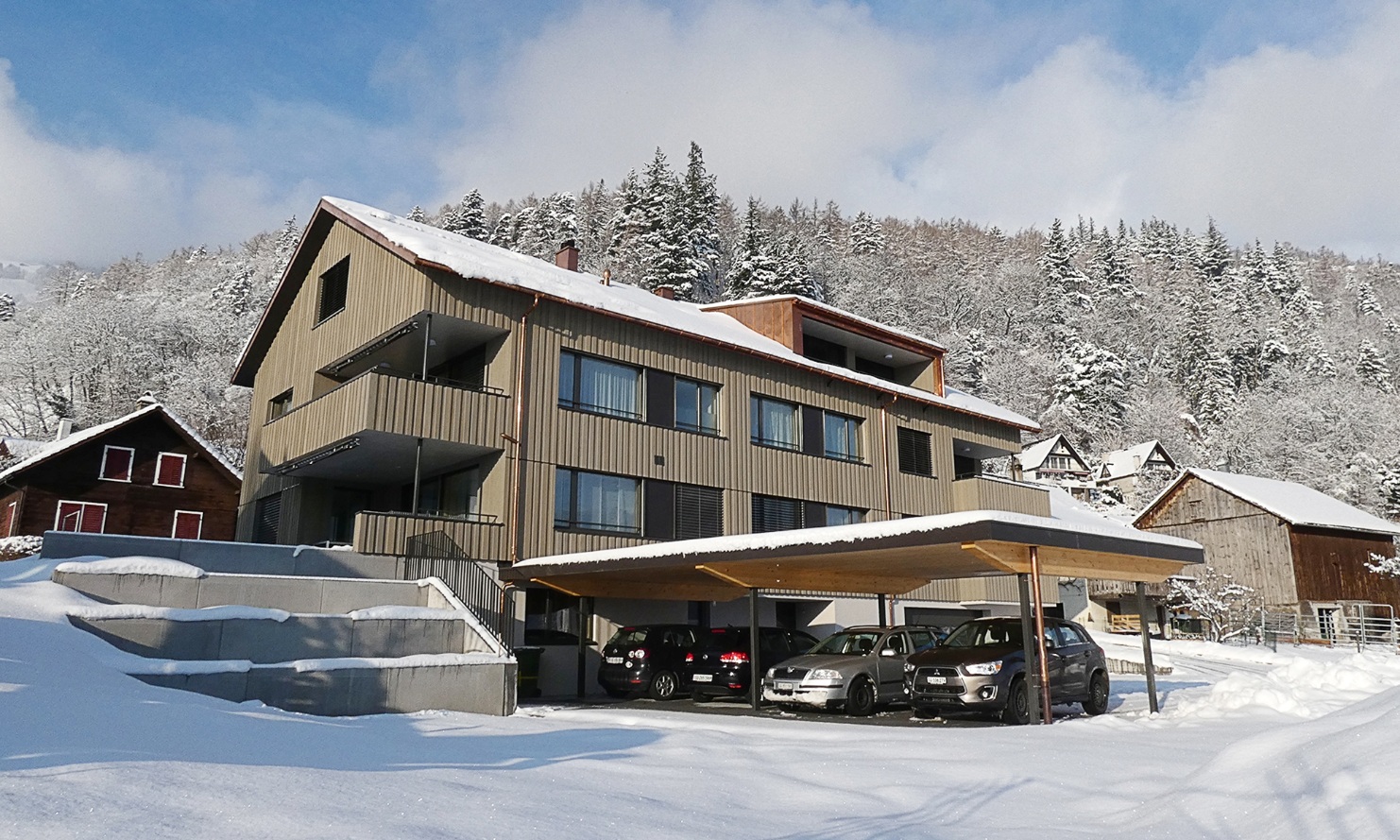 Vue d’ensemble de l’immeuble collectif à Azmoos avec abri pour 4 voitures; en hiver