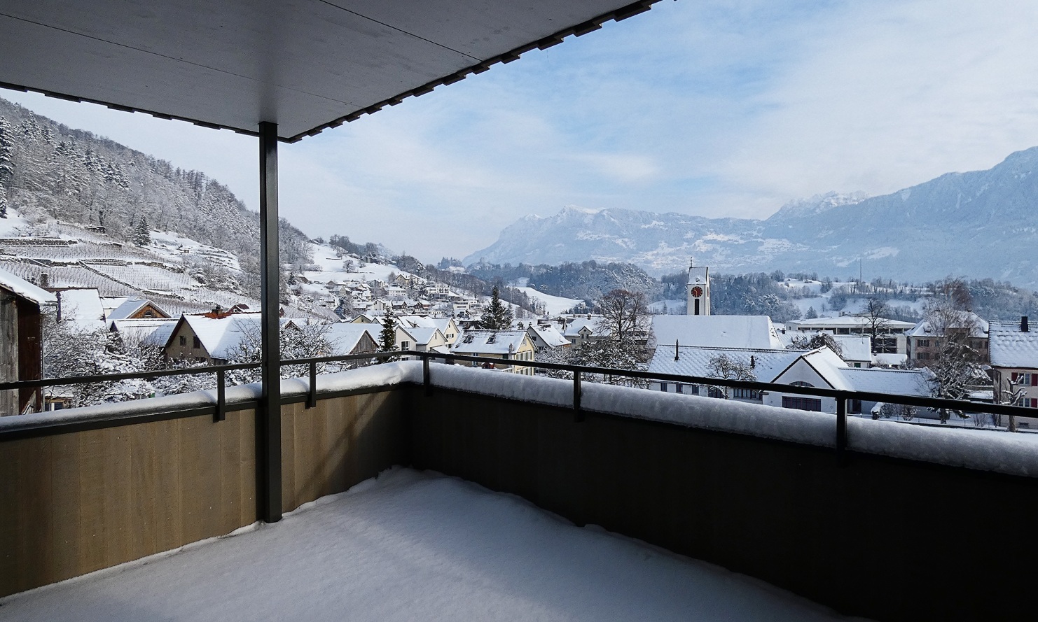 Winterliche Aussicht von einem Balkon des MFH auf Rebberge, Dorf und Berge