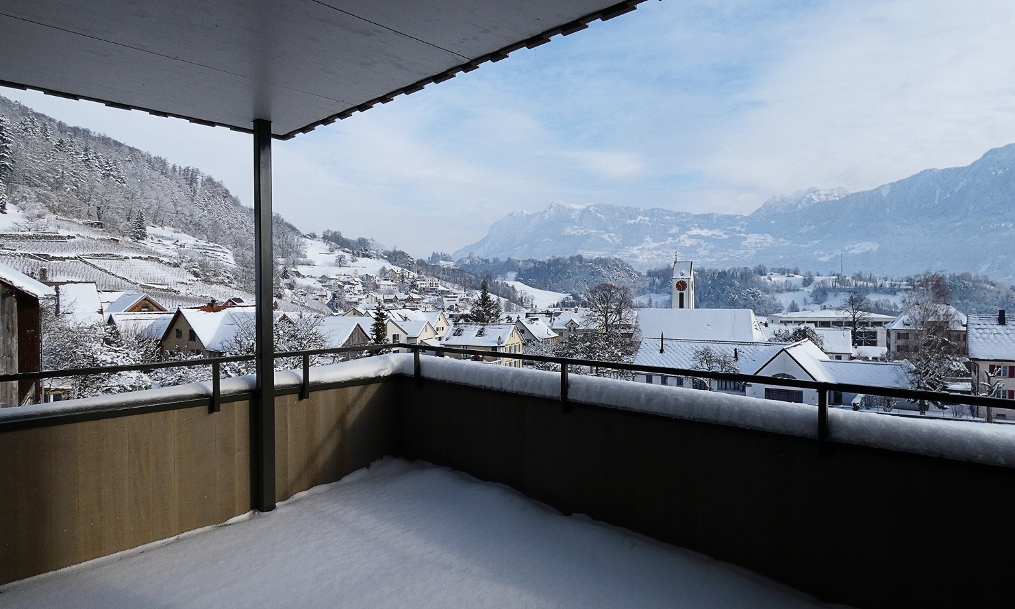 Vue depuis un balcon de l’immeuble collectif à Azmoos sur les vignes, le village et les montagnes en hiver