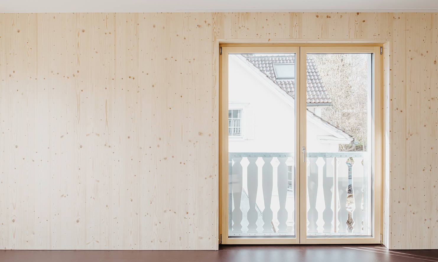 Living room with timber wall and balcony doors