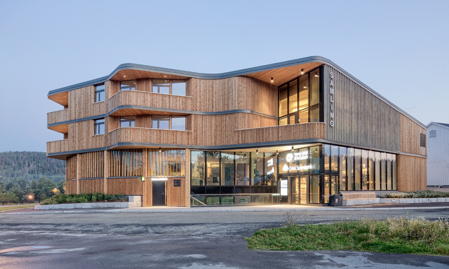 Three-storey ‘Samling’ library building with its curved timber construction, seen in the evening light 