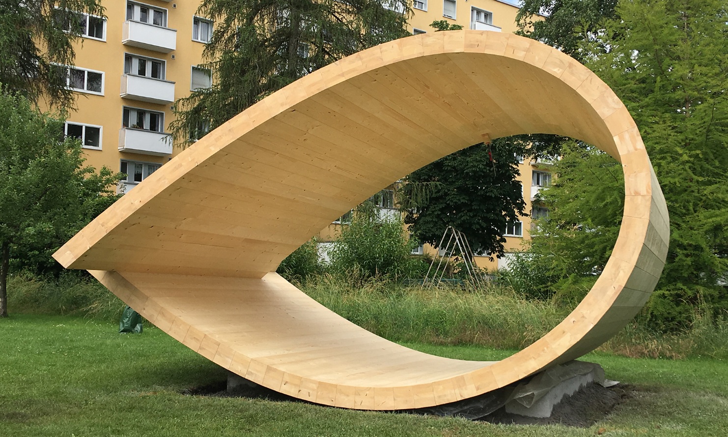 Der Klangpavillon im Park. Im Hintergrund ist ein Mehrfamilienhaus zu sehen.