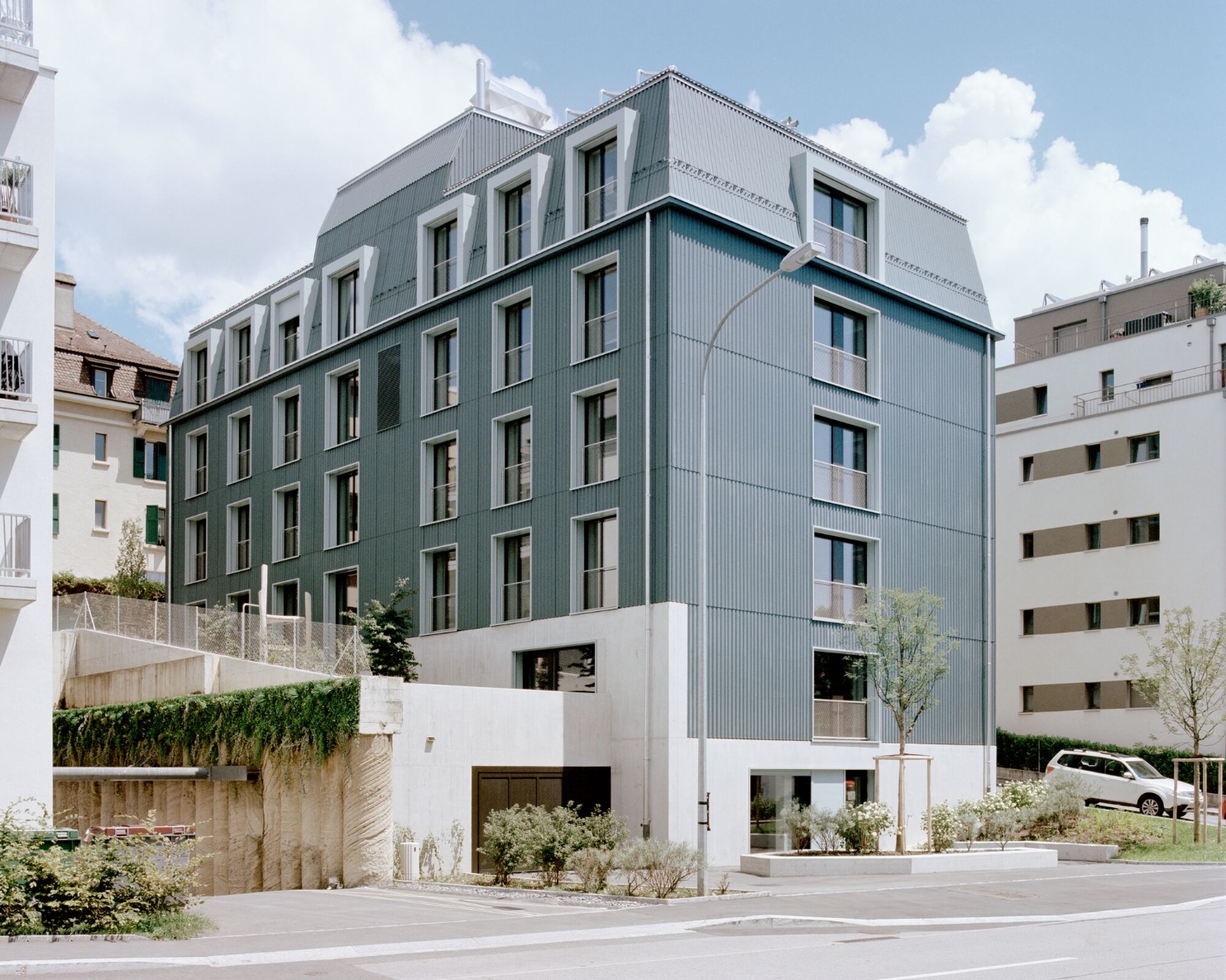 Das Asylzentrum mit Holzfassade und Mansardendach, die typisch sind für den lokalen Baustil. 