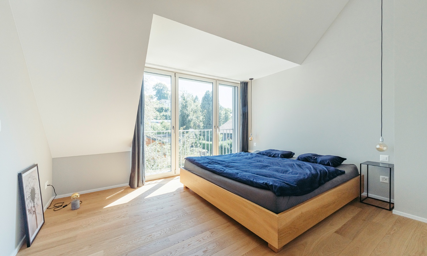 Helles Schlafzimmer mit Doppelbett und Parkett-Fussboden im aufgestockten Einfamilienhaus
