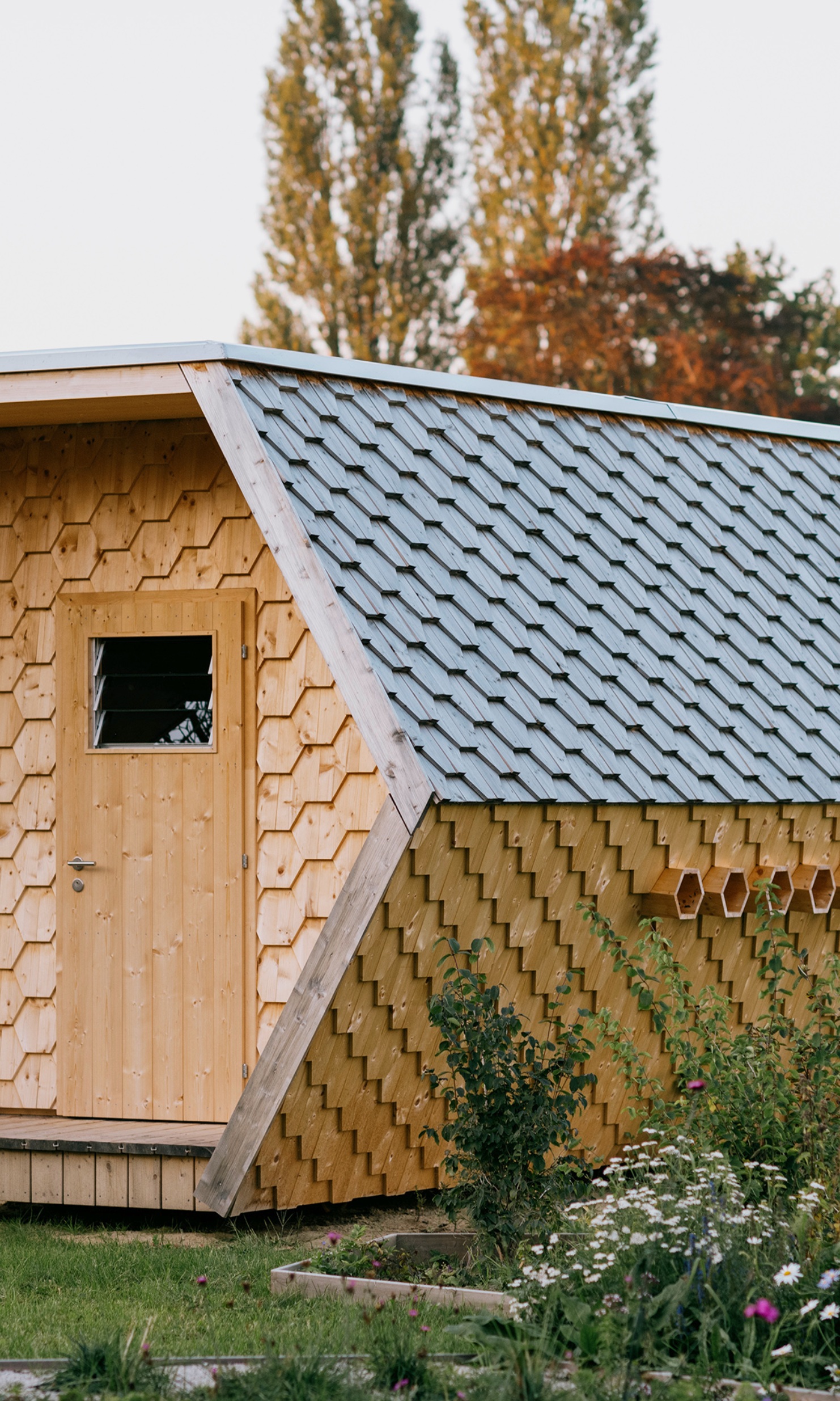 Eingang des ganz aus Holz gefertigte Bienenhauses aus der Nähe