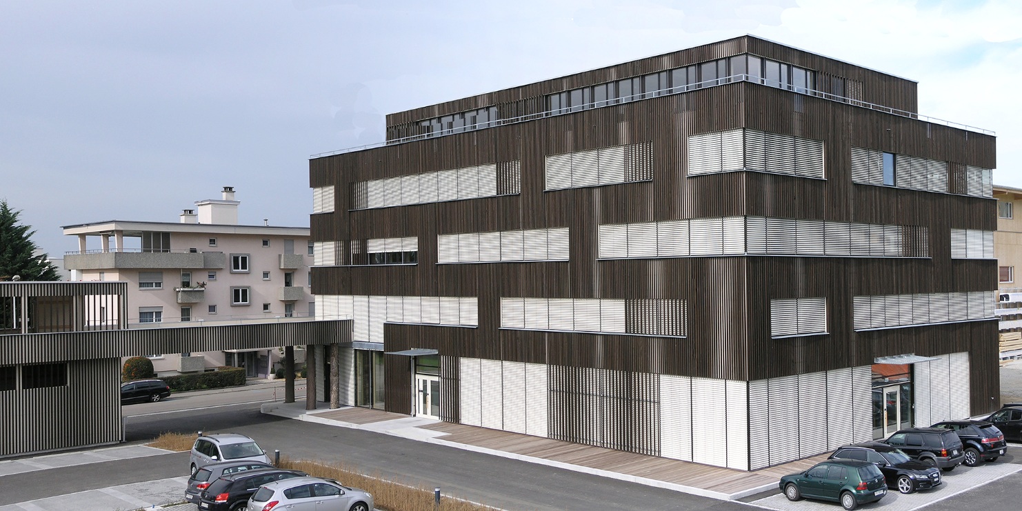 Gesamtaufnahme von Bürogebäude Braun AG mit Vorplatz für Parkplätze sowie einem Eingangsbereich