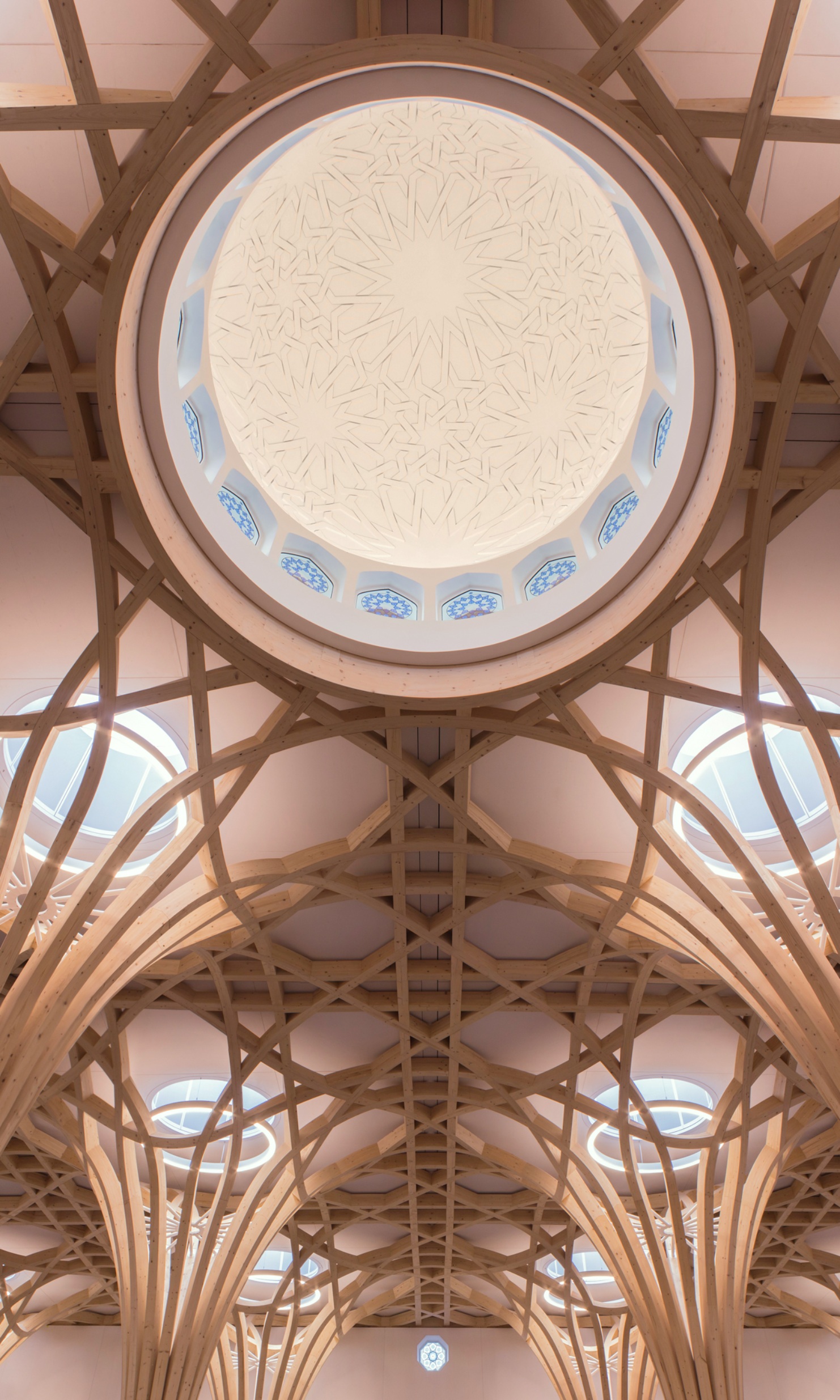 Prise de vue intérieure, sous la coupole de la mosquée de Cambridge. Tout autour, on voit les structures porteuses en bois en forme d’arbres.