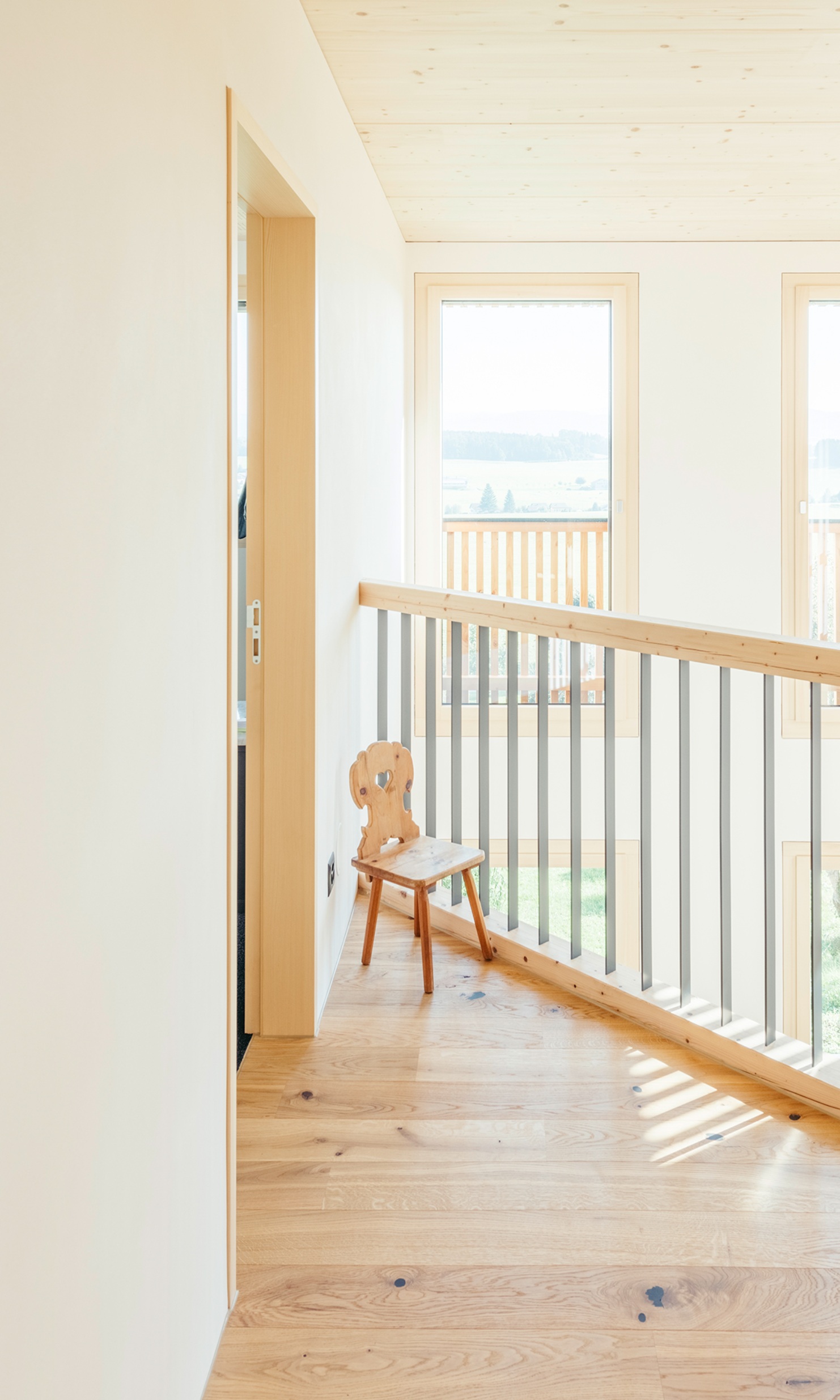 Top-floor mezzanine with railing and wood flooring. 