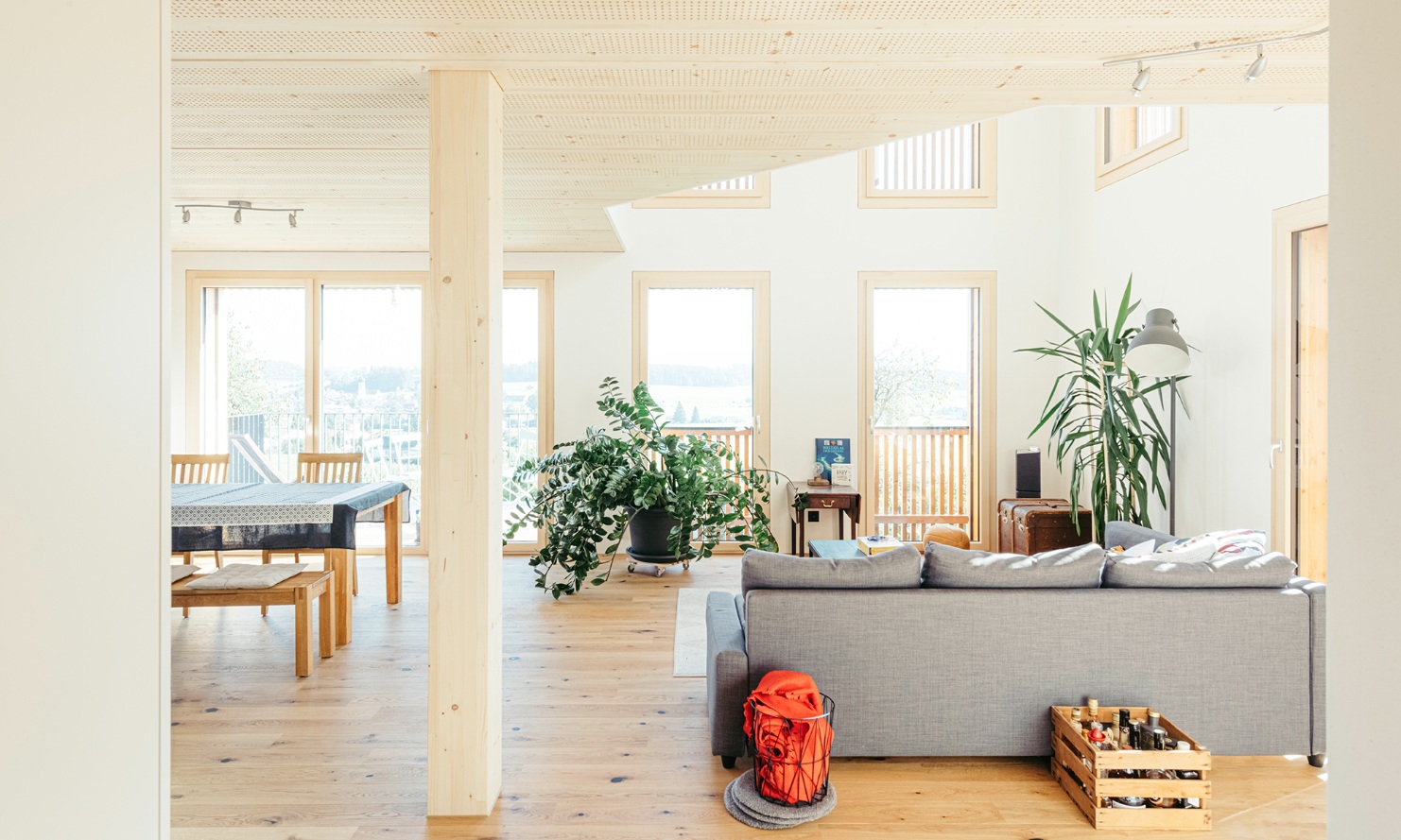 Espace salon et salle à manger ouvert de la maison individuelle avec colonne en bois et plafond Lignatur.