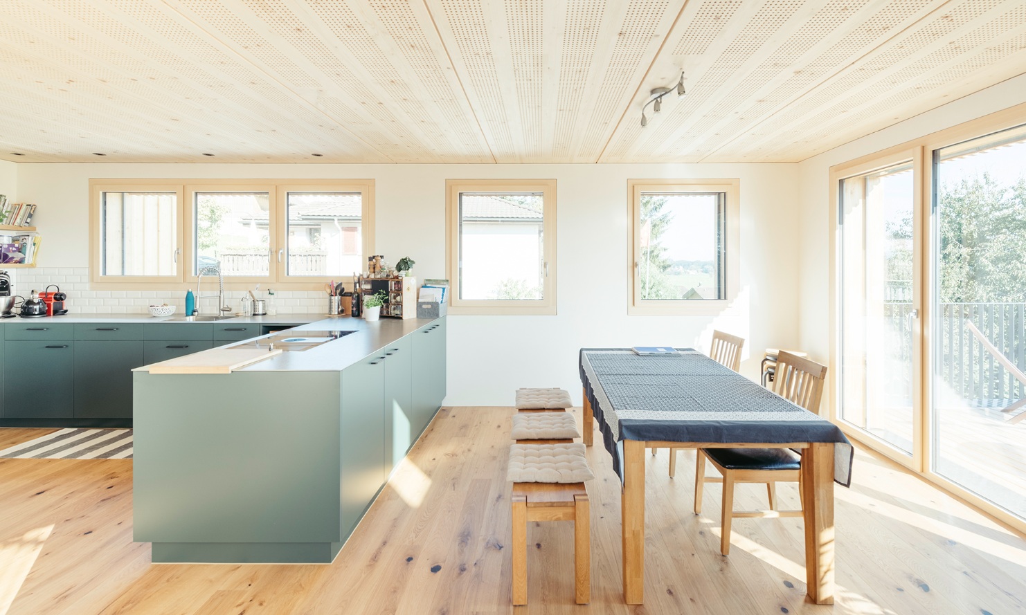 Espace salle à manger ouvert et lumineux et cuisine moderne avec beaucoup de bois