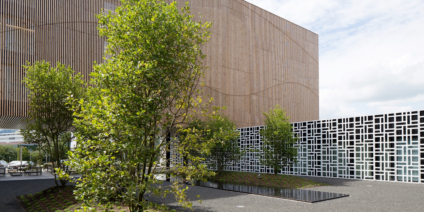 The photograph shows the green spaces and gravel area decorated with a water basin to the rear of the Hotel Säntispark. A covered lounge can also be seen.