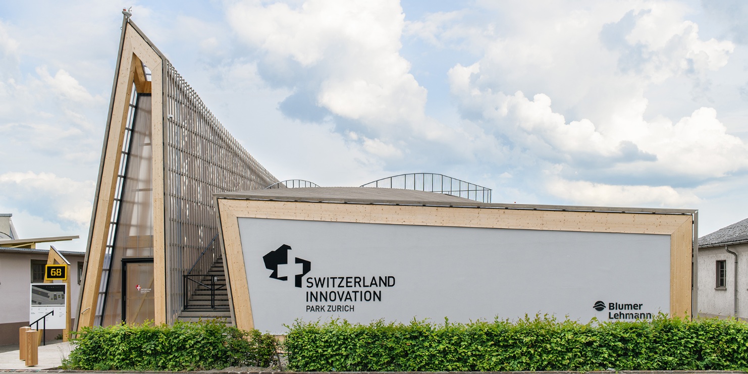 Blick auf den fertigen Bau des Switzerland Innovations Parks mit grüner Hecke. 